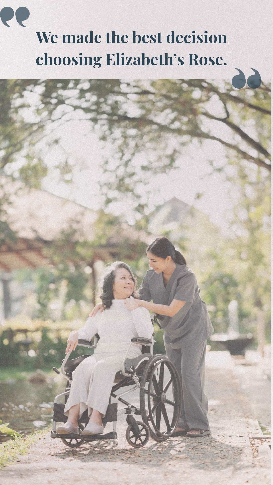 Caregiver attending to an elderly person in a wheelchair outdoors near water and greenery.